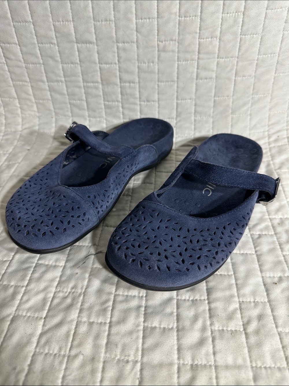 Vionic Lidia blue suede Mary Jane mules feature a laser-cut floral design